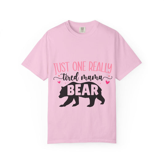 Light pink Comfort Colors short sleeve t-shirt featuring the phrase “Just One Really Tired Mama Bear” in playful pink and black fonts. The design includes a bold black silhouette of a walking bear with the word “BEAR” in pink block letters inside the bear, and small pink hearts for added charm. A cozy, fun, and relatable shirt for moms, perfect for Mother’s Day, new moms, or as a comfy everyday mom life tee.
