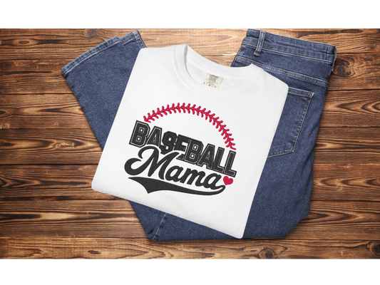 White embroidered “Baseball Mama” shirt with red stitching detail, folded on denim jeans, styled flat lay for baseball mom apparel and gift idea