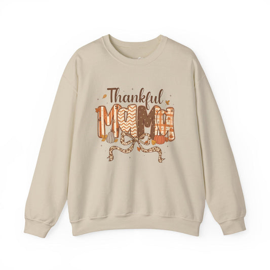 Beige sweatshirt with 'Thankful Mom' text and autumn-themed design on a white background