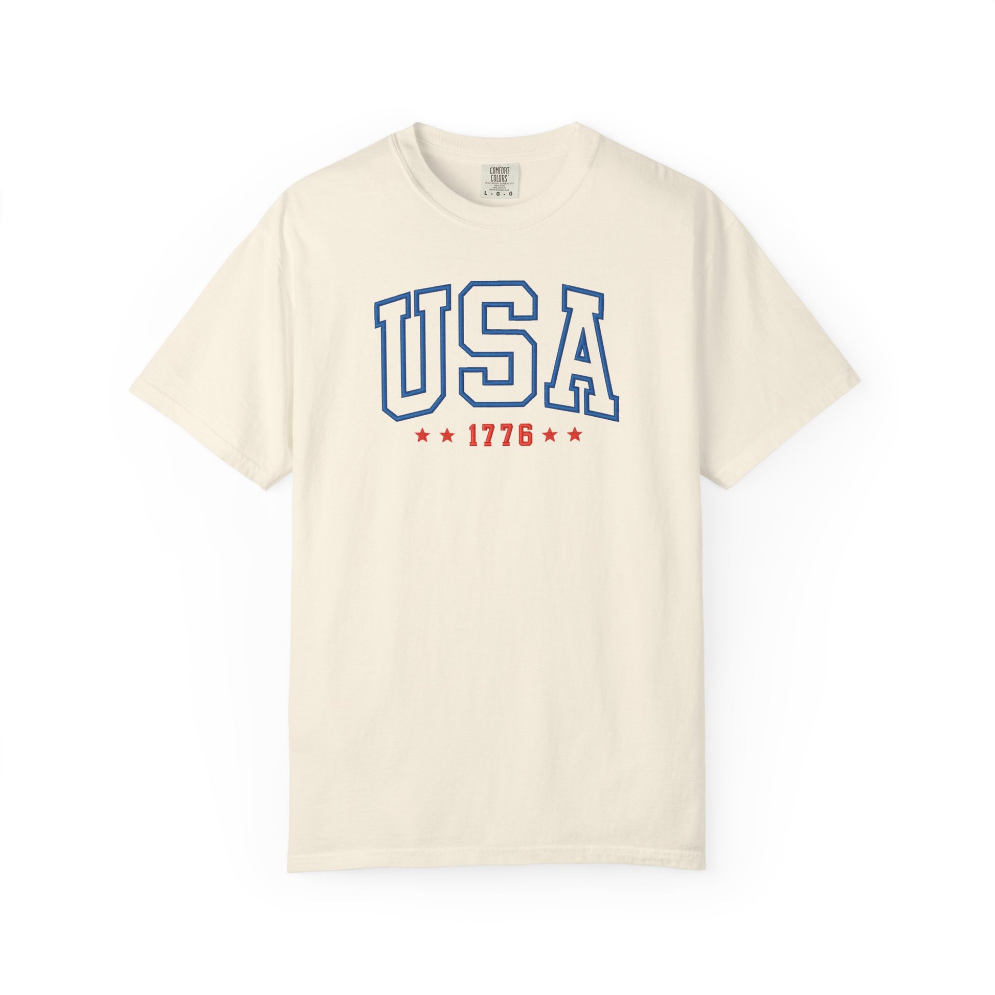 Ivory patriotic USA t-shirt featuring “USA 1776” blue graphic text with USA 1776 design for 4th of July and Independence Day wear