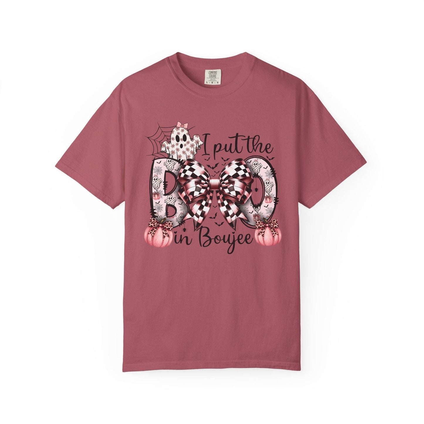Crimson short-sleeve t-shirt with a playful Halloween-themed design that reads “I put the BOO in Boujee.” The word “BOO” is decorated with black and pink patterns, including leopard print and buffalo plaid, accented by a large checkered bow. Surrounding the text are cute seasonal details such as pink pumpkins, a ghost, bats, and a spider web, giving the shirt a stylish and boujee spooky vibe.